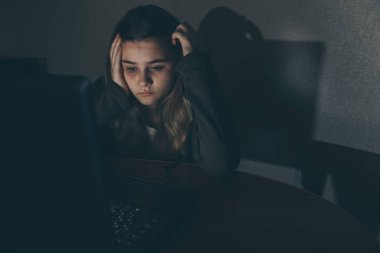 Internet siber zorbalık acı genç kız korkmuş ve cyberbullying depresif. Umutsuzluk kız humilated sınıf arkadaşı tarafından Internet üzerinde görüntü. Belgili tanımlık laptop önünde ağlıyor genç Genç kız