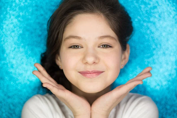 Portrait d'une fille heureuse excitée bouche ouverte gardant les mains sur son visage isolé sur fond bleu — Photo