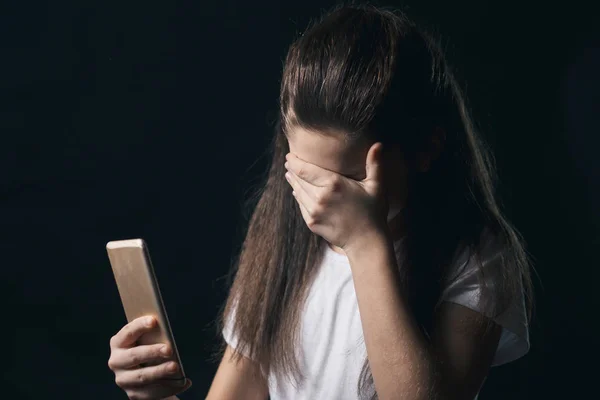 Mladé děvče nešťastné zranitelných pomocí mobilního telefonu, strach a zoufalství, utrpení online zneužívání cyberbullying je pronásledován — Stock fotografie