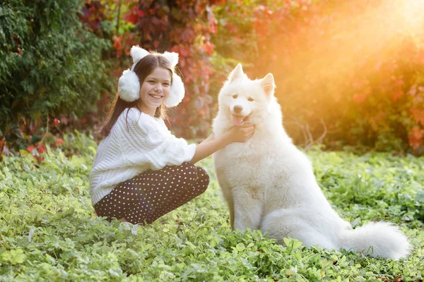 Criança feliz brincando com cão no campo verde — Fotografia de Stock