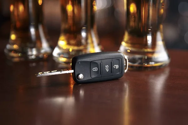 Concetto di guida e bere. Chiave dell'auto su un tavolo di legno, pub — Foto Stock