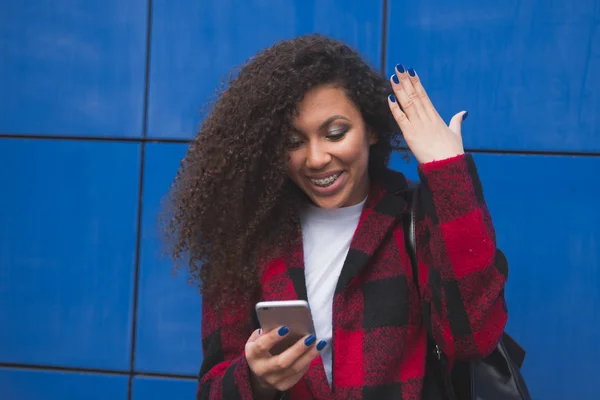 happy young african american uni student using cell phone