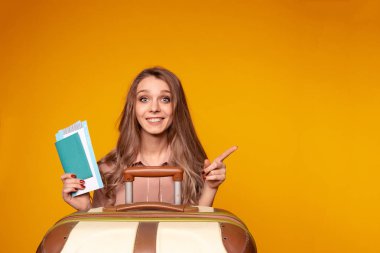 miling kadın traveler pasaport ve bilet ve kredi kartı tutan. sarı duvar