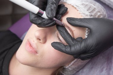 Kalıcı makyaj kaşları için. Microblading kaş. Şevval özçelik güzellik kadın yüzü için kaş dövme yapıyor. Güzel genç kız bir güzellik