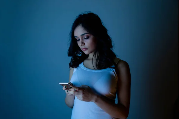 Chica excesivamente sentado en el teléfono en casa. él es una víctima de acoso en línea acosador redes sociales — Foto de Stock