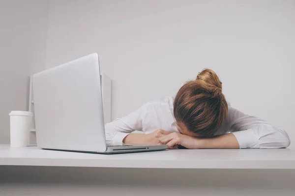 Sobretrabajado y cansado durmiendo sobre un portátil en un escritorio en el trabajo en su — Foto de Stock