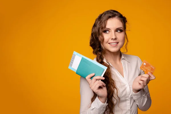 Pretty smiling woman buying tickets online by credit card, buying tickets online