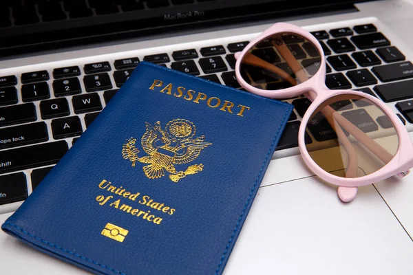 Masada dizüstü bilgisayar ile pasaport kitap — Stok fotoğraf