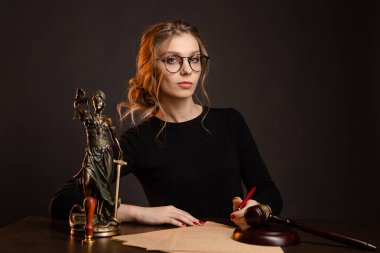 Genç ve güzel kadın bir gözlük ve bir siyah elbise oturma ve wrighting importaint belgesi