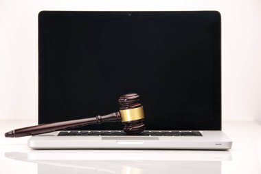 Closeup of laptop and mallet on table in courtroom clipart