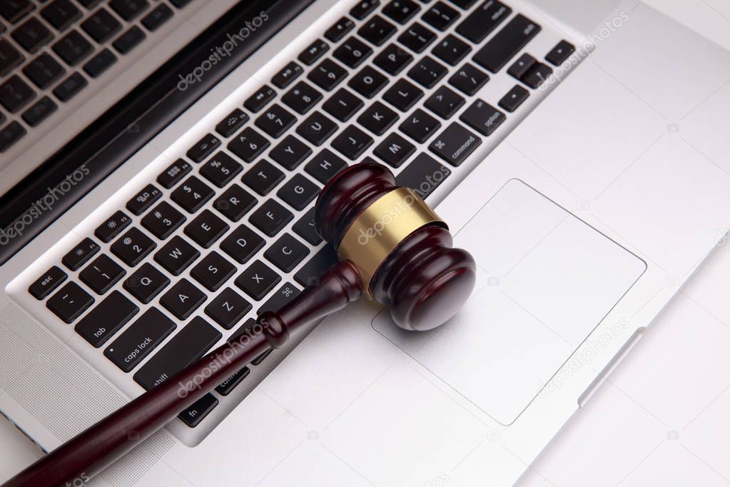 Wooden law gawel on laptop keyboard, judgement