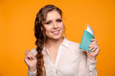 Hoş gülümseyen kadın holding pasaport ve bilet uçan portre