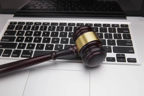 Wooden gavel on laptop keyboard. auction, online, law, technology, justice