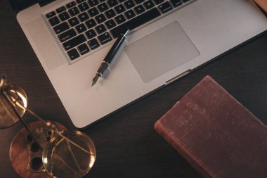 Adalet ve hukuk kavramı. Avukat işyeri dizüstü bilgisayar ve koyu ahşap belgelerle