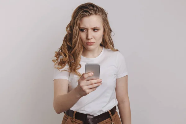 Portret van gefrustreerd meisje met haar telefoon. Problemen met cellphone. — Stockfoto