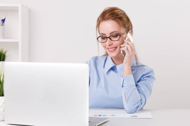 Güzel sarışın Ofis telefonu onun işyerinde konuşurken kız.