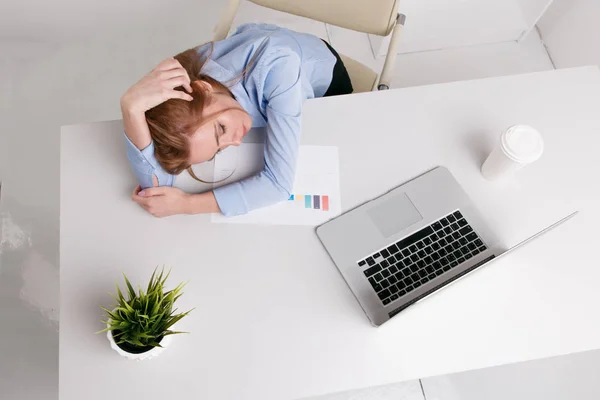 Joven chica de oficina sentada en su lugar de trabajo sintiéndose mal. La mujer tiene dolor de cabeza. Pareces cansado . — Foto de Stock