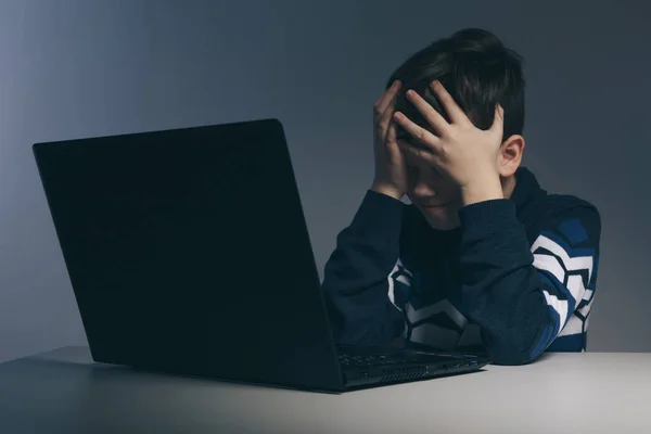 Close-up foto van pesten tiener jongen gevoel overstuur infront van de computer. Gestresst trieste jongen is pesten door zijn klasgenoten. — Stockfoto