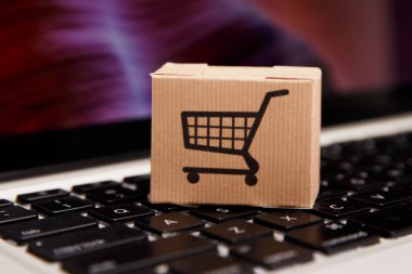 Online alışveriş. e-ticaret ve teslimat hizmeti kavramı: kağıt karton bir arabası ya da logo üstünde a laptop klavye trolley, perakendeci siteleri üzerinden gelen müşteriler sipariş şeyler gösteriyor