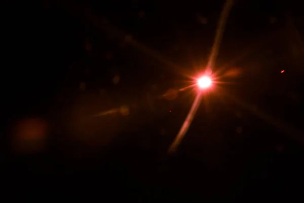 Abstrakte Linsen leuchten rotes Licht über schwarzem auf — Stockfoto