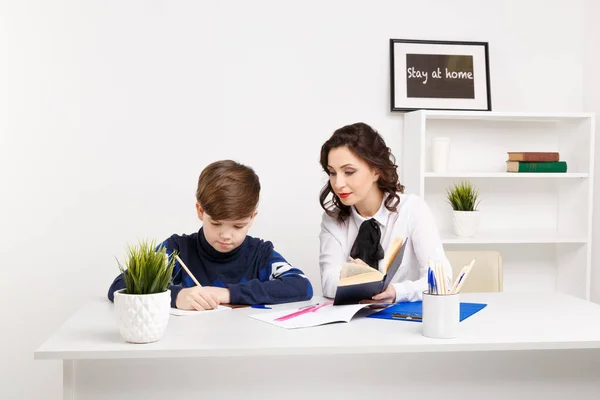 女教師は、彼の宿題に十代の少年をのに役立ちます。宿題を一緒にすること. — ストック写真