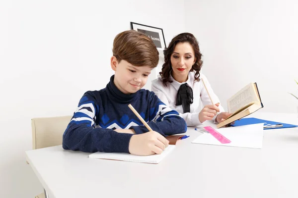 Tutor and student sitting in the white room and doing tasks for — Stock Photo, Image