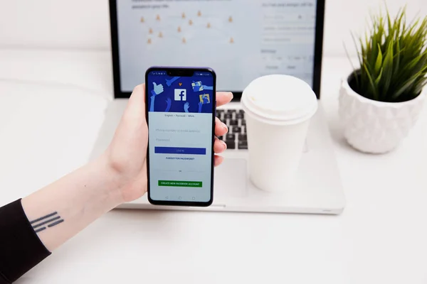Tula, Rusia - 18 de febrero de 2019: logotipo de la aplicación de redes sociales de Facebook en el inicio de sesión, página de registro de registro en la pantalla de la aplicación móvil en dispositivos inteligentes iPhone en personas de negocios a mano en — Foto de Stock