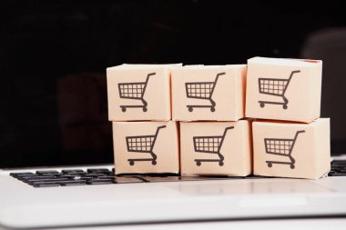 Online alışveriş e-ticaret ve teslimat hizmeti kavramı: kağıt karton ile bir alışveriş sepeti veya logo üstünde a laptop klavye trolley, perakendeci siteler internet üzerinden gelen müşteriler sipariş şeyler gösteriyor