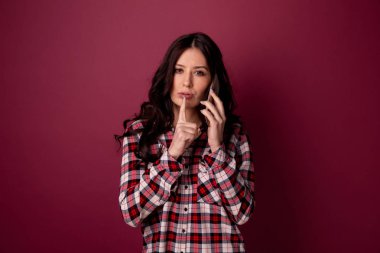 Sessizlik ve konuşan telefon tutmak için gösterilen güzel bir kadın fotoğrafı.