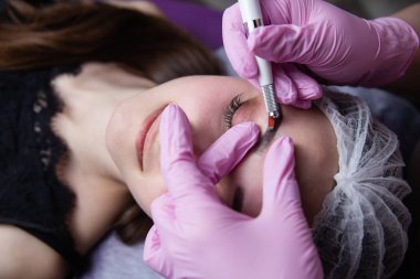 Kalıcı makyaj kaşları için. Microblading kaş. Şevval özçelik güzellik kadın yüzü için kaş dövme yapıyor. Güzel genç kız bir güzellik