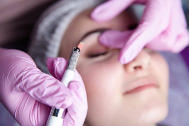 Kalıcı makyaj kaşları için. Microblading kaş. Şevval özçelik güzellik kadın yüzü için kaş dövme yapıyor. Güzel genç kız bir güzellik