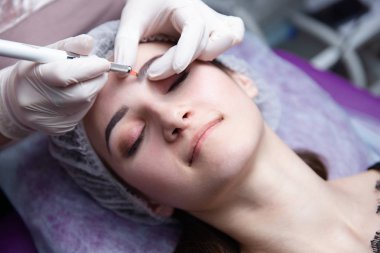 Kalıcı makyaj kaşları için. Microblading kaş. Şevval özçelik güzellik kadın yüzü için kaş dövme yapıyor. Güzel genç kız bir güzellik