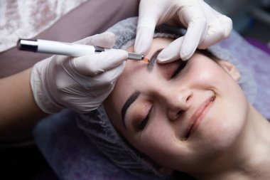 Kalıcı makyaj kaşları için. Microblading kaş. Şevval özçelik güzellik kadın yüzü için kaş dövme yapıyor. Güzel genç kız bir güzellik