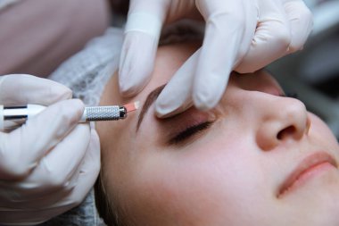 Kalıcı makyaj kaşları için. Microblading kaş. Şevval özçelik güzellik kadın yüzü için kaş dövme yapıyor. Güzel genç kız bir güzellik