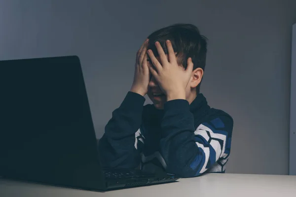 Close-up foto van pesten tiener jongen gevoel overstuur infront van de computer. Gestresst trieste jongen is pesten door zijn klasgenoten. — Stockfoto