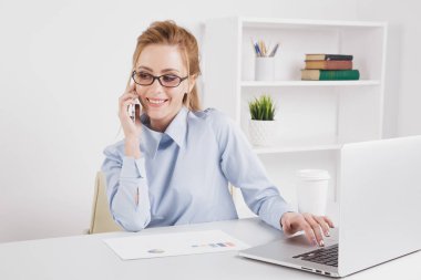 Güzel sarışın Ofis telefonu onun işyerinde konuşurken kız.