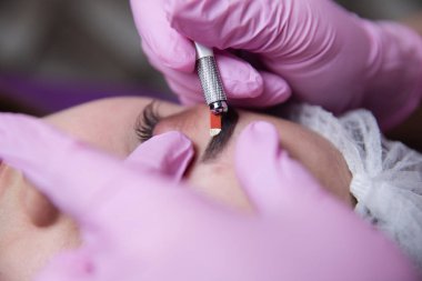 Kalıcı makyaj kaşları için. Microblading kaş. Şevval özçelik güzellik kadın yüzü için kaş dövme yapıyor. Güzel genç kız bir güzellik