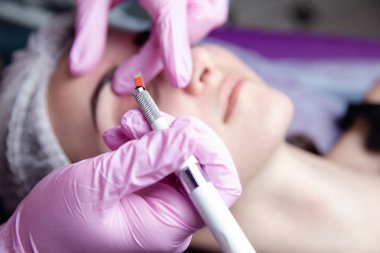 Kalıcı makyaj kaşları için. Microblading kaş. Şevval özçelik güzellik kadın yüzü için kaş dövme yapıyor. Güzel genç kız bir güzellik