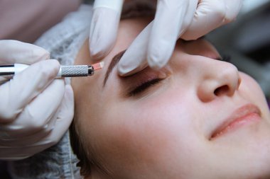 Kalıcı makyaj kaşları için. Microblading kaş. Şevval özçelik güzellik kadın yüzü için kaş dövme yapıyor. Güzel genç kız bir güzellik