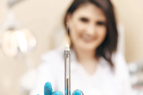 Foto de primer plano del dentista femenino en la sala dental que sostiene la jeringa oral . —  Fotos de Stock