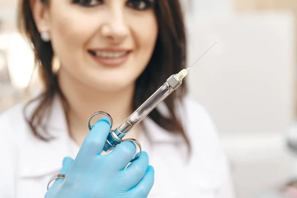 Zbliżenie zdjęcie kobieta dentysty w sali stomatologiczne, trzymając strzykawkę doustną. — Zdjęcie stockowe