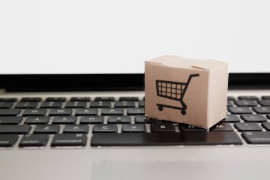 Online alışveriş. e-ticaret ve teslimat hizmeti kavramı: kağıt karton bir arabası ya da logo üstünde a laptop klavye trolley, perakendeci siteler internet üzerinden gelen müşteriler sipariş şeyler gösteriyor