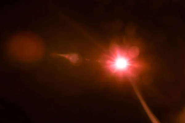 Lentille abstraite lumière rouge fusée sur noir — Photo