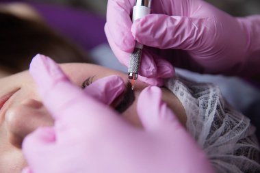 Kalıcı makyaj kaşları için. Microblading kaş. Şevval özçelik güzellik kadın yüzü için kaş dövme yapıyor. Güzel genç kız bir güzellik
