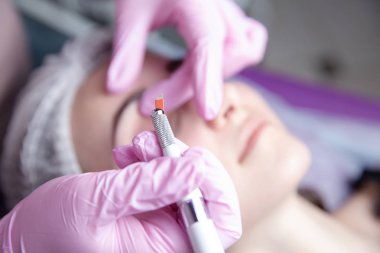 Kalıcı makyaj kaşları için. Microblading kaş. Şevval özçelik güzellik kadın yüzü için kaş dövme yapıyor. Güzel genç kız bir güzellik