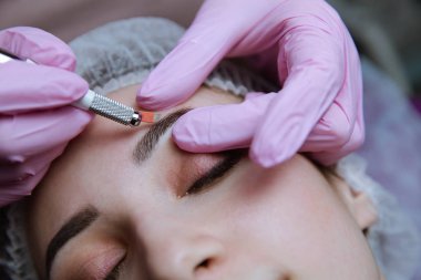 Kalıcı makyaj kaşları için. Microblading kaş. Şevval özçelik güzellik kadın yüzü için kaş dövme yapıyor. Güzel genç kız bir güzellik