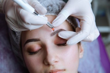 Kalıcı makyaj kaşları için. Microblading kaş. Şevval özçelik güzellik kadın yüzü için kaş dövme yapıyor. Güzel genç kız bir güzellik