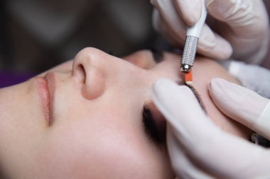 Kalıcı makyaj kaşları için. Microblading kaş. Şevval özçelik güzellik kadın yüzü için kaş dövme yapıyor. Güzel genç kız bir güzellik