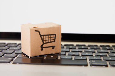 Online alışveriş. e-ticaret ve teslimat hizmeti kavramı: kağıt karton bir arabası ya da logo üstünde a laptop klavye trolley, perakendeci siteler internet üzerinden gelen müşteriler sipariş şeyler gösteriyor