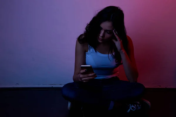 Menina excessivamente sentado ao telefone em casa. ele é vítima de bullying online redes sociais Stalker — Fotografia de Stock